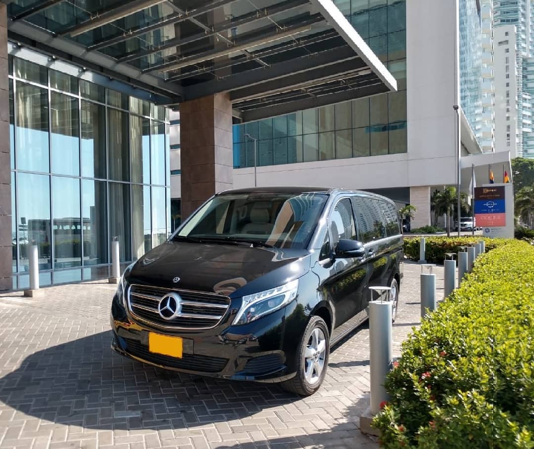 Schwarze Mercedes-Benz V-Klasse mit Chauffeur vor einem Hoteleingang